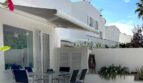 Sonnige Terrasse mit Esstisch, Markise und Pflanzen eines modernen Reihenhauses in Llucmajor