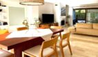 Helles Wohn-Esszimmer mit Marmorböden, Holztisch und modernem TV-Bereich im Reihenhaus Llucmajor