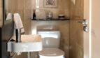 Kleines WC mit Marmorverkleidung, Wandwaschbecken und Toilette unter Gewölbedecke im Reihenhaus Llucmajor