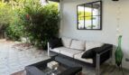 Überdachte Terrasse mit Rattanmöbeln, Spiegel und Gartenblick – Reihenhaus Llucmajor