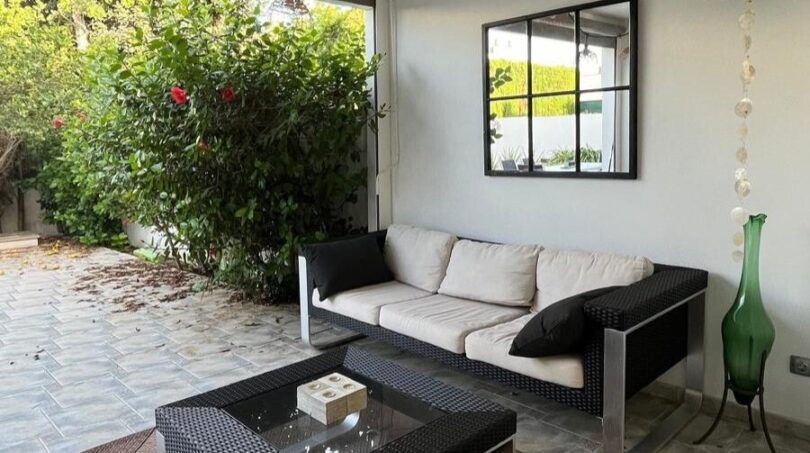 Überdachte Terrasse mit Rattanmöbeln, Spiegel und Gartenblick – Reihenhaus Llucmajor