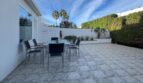 Gepflegte Terrasse mit Esstisch, Stühlen und üppigem Grün beim Reihenhaus in Llucmajor