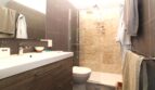 Modernes Badezimmer mit Glasdusche, Wandtoilette und Holzunterschrank in Bergjuwel Esporles