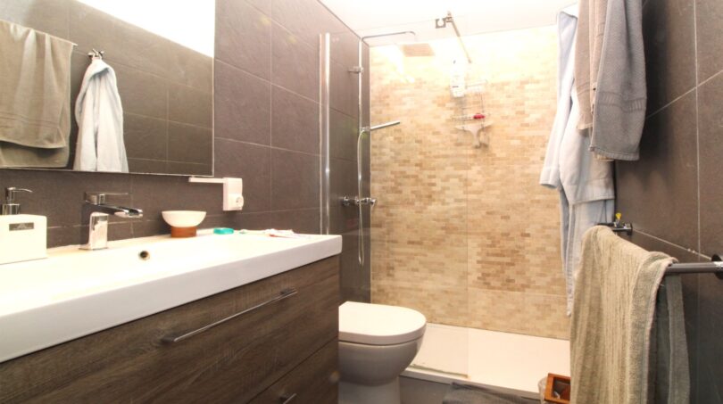 Modernes Badezimmer mit Glasdusche, Wandtoilette und Holzunterschrank in Bergjuwel Esporles