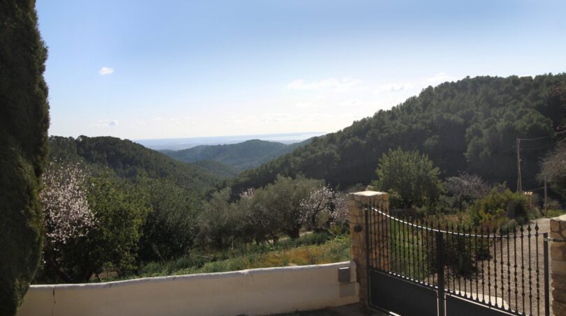 Einfahrt mit Eisentor, Blick auf bewaldete Berge und Meer, Finca Esporles