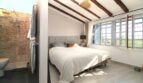 Helles Schlafzimmer mit Doppelbett, Holzbalkendecke, Ensuite-Bad und großen Fenstern in Bergjuwel Esporles