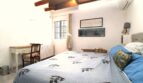 Schlafzimmer mit Doppelbett, Holzbalkendecke, Klimaanlage und rustikalem Charme in Bergimmobilie Esporles