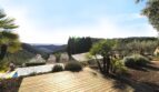 Holzterrasse mit Palmen, Pool und Panoramablick auf die Berglandschaft der Immobilie in Esporles