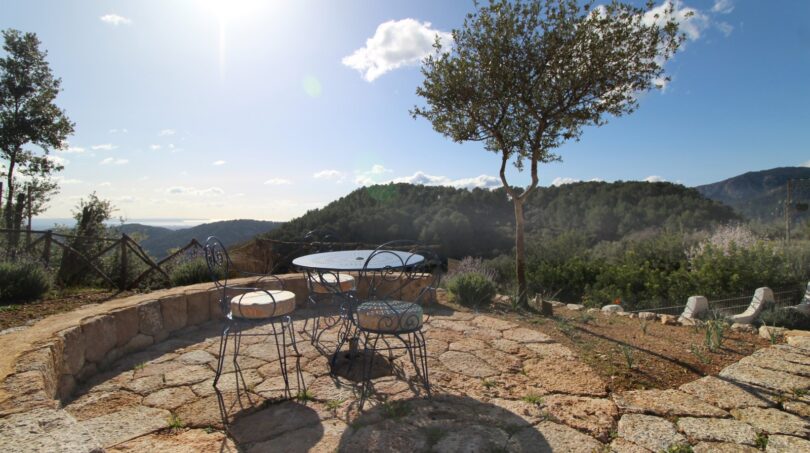 Steinerne Terrasse mit schmiedeeisernen Möbeln, Panoramablick auf Berglandschaft bei Esporles, Mallorca