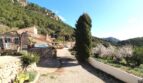Rustikale Finca in Esporles mit Kiesweg, Pool, Zypressen und Bergpanorama der Tramuntana.