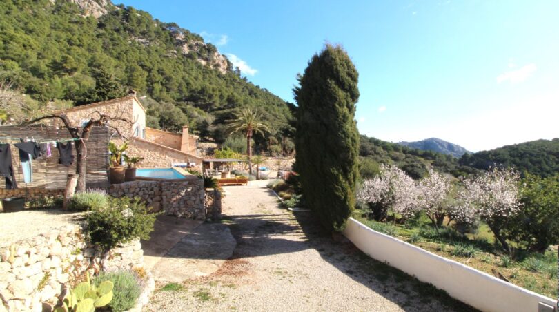 Rustikale Finca in Esporles mit Kiesweg, Pool, Zypressen und Bergpanorama der Tramuntana.