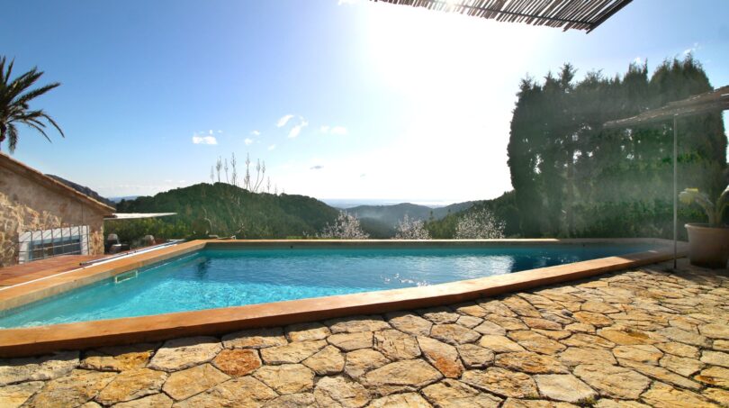 Infinity-Pool mit Natursteintetrasse und Panoramablick auf die Berge von Esporles, Mallorca