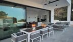 Moderne Terrasse mit Outdoor-Essbereich, Lounge und großen Glasfronten zum Innenbereich in Cala Pi