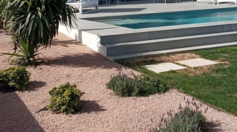Moderne Luxusvilla in Cala Pi mit Pool, Gravel-Garten, Glasbalkon und mediterraner Bepflanzung.
