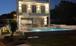 Moderne Villa in Cala Pi bei Nacht mit beleuchtetem Pool, Loungebereich und zweistöckiger weißer Fassade