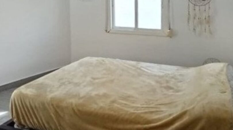 Helles Schlafzimmer im Penthouse mit Doppelbett, Kronleuchter, Traumfänger und natürlichem Lichteinfall