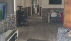 Offener Wohnbereich mit Holzoptikboden, TV-Wand, Steinelementen und Durchgang zum Essbereich im Penthouse Palma.