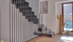 Modernes Treppenhaus mit Stahlgeländer, Holzboden und Kaktus-Deko im Stadthaus Alaró