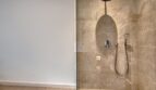 Modernes Duschbad mit Regendusche, Handbrause und Natursteinoptik-Fliesen im Stadthaus Alaró