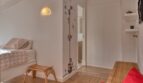 Kinderzimmer mit Hochmesserwand, Wolkenlampe, Holzboden und rotem Sitzsack im Stadthaus Alaró