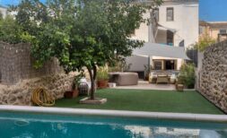 Outdoor area with pool, lemon tree and hot tub in front of modernized townhouse in Alaró