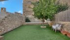 Gepflegter Innengarten mit Kunstrasen, Zitronenbaum, Pool und Natursteinmauern des Stadthauses in Alaró