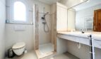 Bright bathroom with shower, wall-mounted toilet and marble washbasin in Mediterranean villa, Santa Ponça