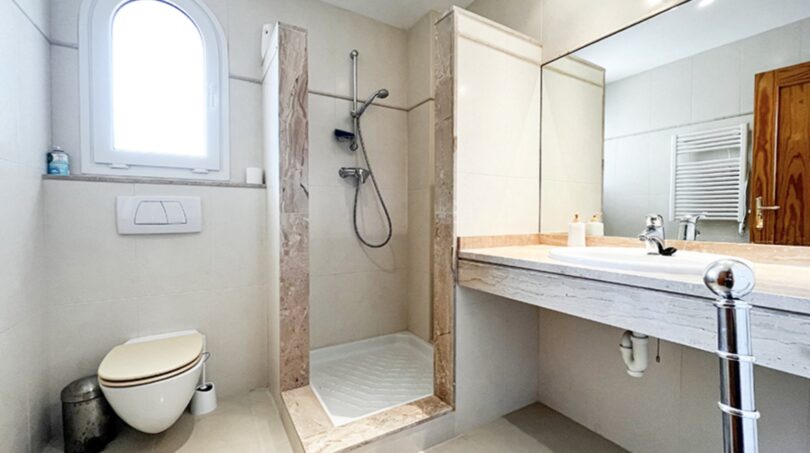 Bright bathroom with shower, wall-mounted toilet and marble washbasin in Mediterranean villa, Santa Ponça
