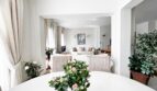 Bright dining room with white table, bouquet of roses and view into living room, Mediterranean villa Santa Ponça