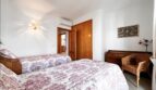 Bright bedroom in Santa Ponça with two beds, Toile-de-Jouy bedding, wooden furniture and air conditioning.