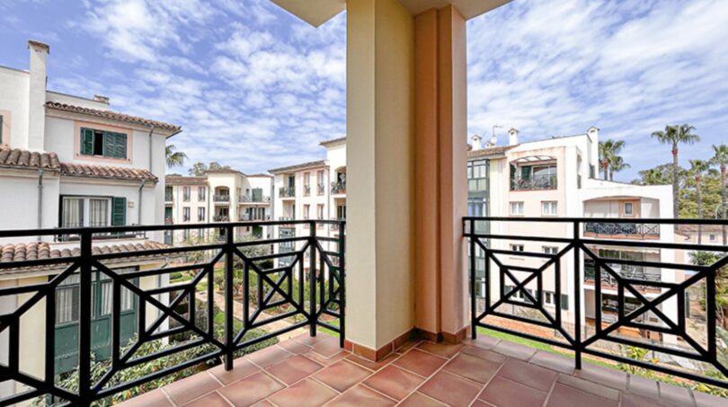 Spacious balcony with wrought iron railing and view of Mediterranean residential complex in Santa Ponça