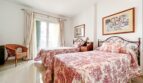 Bright double bedroom with two beds, red and white bedding, balcony and Mediterranean flair in Santa Ponça