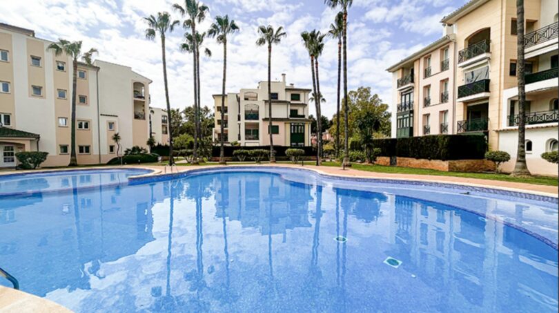 Communal pool with palm trees and Mediterranean residential complexes in Santa Ponça