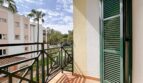 Sunny balcony with green shutters and view of well-maintained garden in Santa Ponça