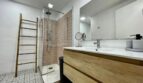 Modernes Badezimmer mit Glasdusche, Holzwaschtisch und Mosaikbodenfliesen in Inca