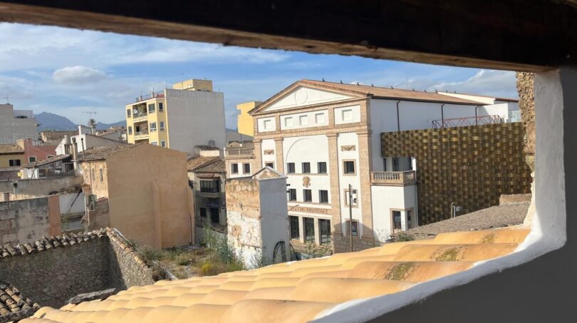 Dachfensterausblick auf historische Altstadt von Inca mit klassizistischem Theater und Terrakottadächern