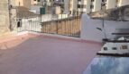 Dachterrasse mit rosa Bodenbelag und Metallgeländer, Blick auf Stadtgebäude in Inca, Mallorca
