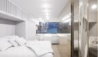 Helles Loft-Schlafzimmer mit weißem Doppelbett, modernem Design und Panoramafenster mit Meerblick in Palma