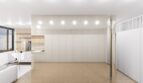 Modernes Loft in Palma: Helles Wohnzimmer mit Marmorboden, goldener Säule und eleganter Wandverkleidung.