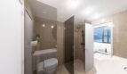 Modernes Loft-Bad in Palma: Glastrennwände, Regendusche, WC-Bereich & Meerblick durchs Fenster