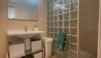 Helles Badezimmer mit Glasbausteinwand, Dusche, Waschtisch und Spiegel im Penthouse Palma de Mallorca.