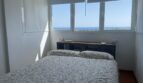Helles Schlafzimmer des Penthouse in Palma mit Doppelbett und atemberaubendem Meerblick durch große Fenster.