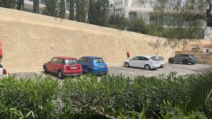 Parkplatz des Penthouse-Komplexes in Palma de Mallorca mit mehreren Stellplätzen und mediterraner Bepflanzung.