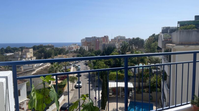 Penthouse-Balkon in Palma de Mallorca mit blauem Geländer, Stadtblick und Meerblick im Hintergrund.