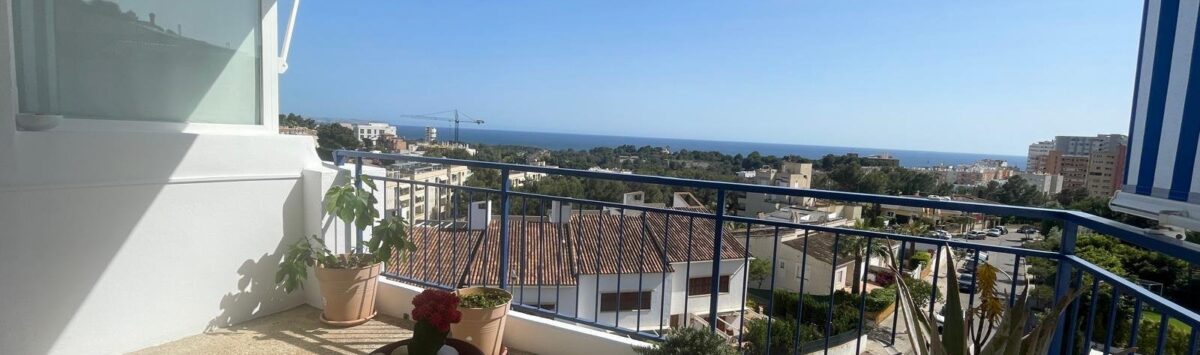 Sonnige Penthouse-Terrasse mit Meerblick, Markise, Pflanzen und Lounge-Möbeln in Palma de Mallorca.
