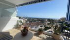 Sonnige Penthouse-Terrasse mit Meerblick, Markise, Pflanzen und Lounge-Möbeln in Palma de Mallorca.