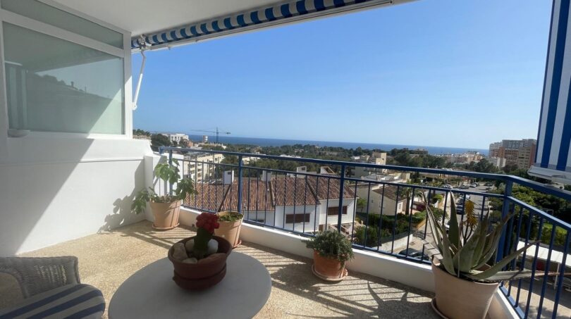 Sonnige Penthouse-Terrasse mit Meerblick, Markise, Pflanzen und Lounge-Möbeln in Palma de Mallorca.