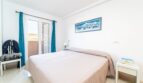 Helles Schlafzimmer mit Doppelbett, Balkon und blauen Vorhängen in exklusiver Wohnung in Artà