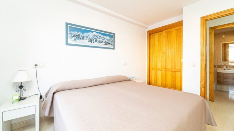 Helles Schlafzimmer mit Doppelbett, Holzschrank und En-suite-Bad in exklusiver Wohnung in Artà.
