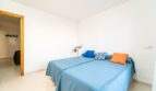 Helles Schlafzimmer mit zwei Einzelbetten, blauen Tagesdecken und bunten Kissen in Wohnung in Artà.